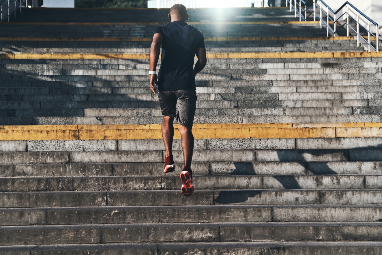 Person climbing concrete stadium steps, symbolizing the journey of building good habits through consistent effort and gradual progress