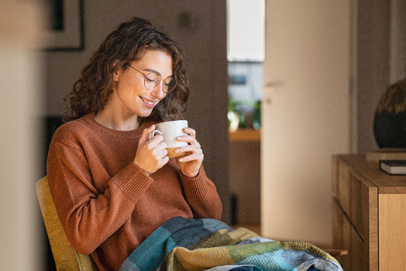 Woman embracing holistic health practices with calming tea ritual at home, promoting mindfulness and self-care